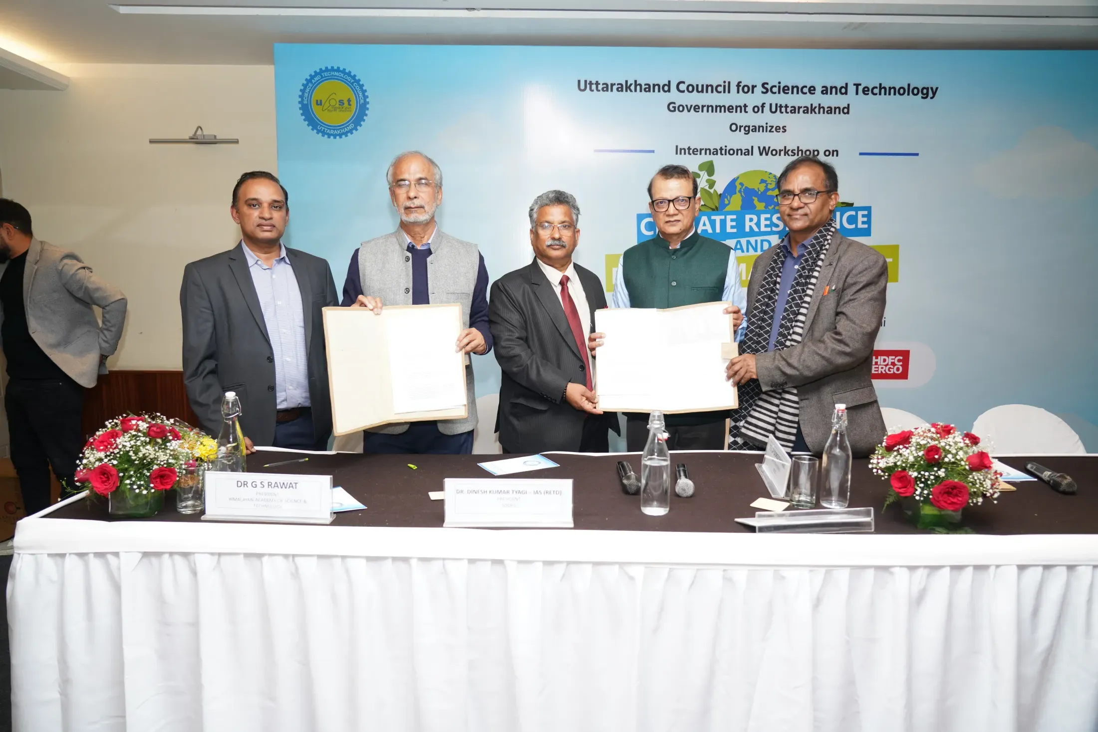 Officials exchanging signed agreements at a UCOST international workshop on climate resilience
